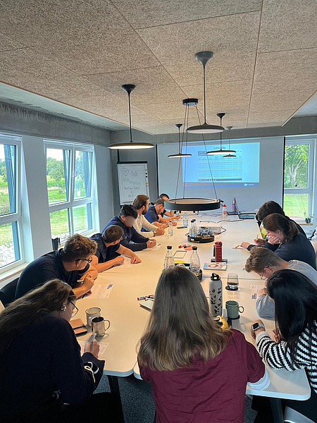 Die Teilnehmenden des Workshops NextGen Vielfalt sitzen an einem großen Tisch